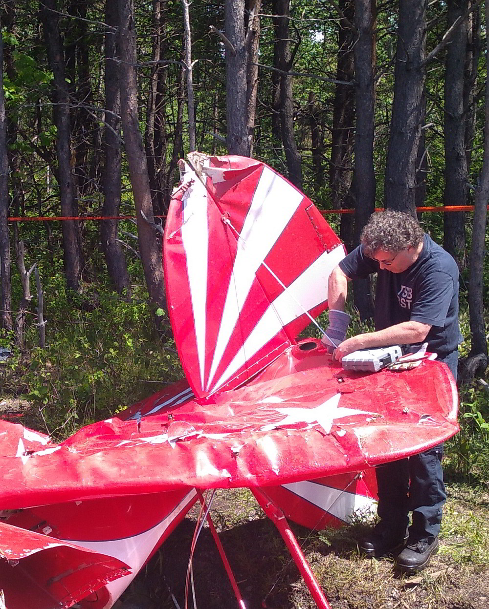 TSB investigator examining the wreckage of a Pitts S2E aircraft following an accident in Saint-Jean-Port-Joli, Quebec