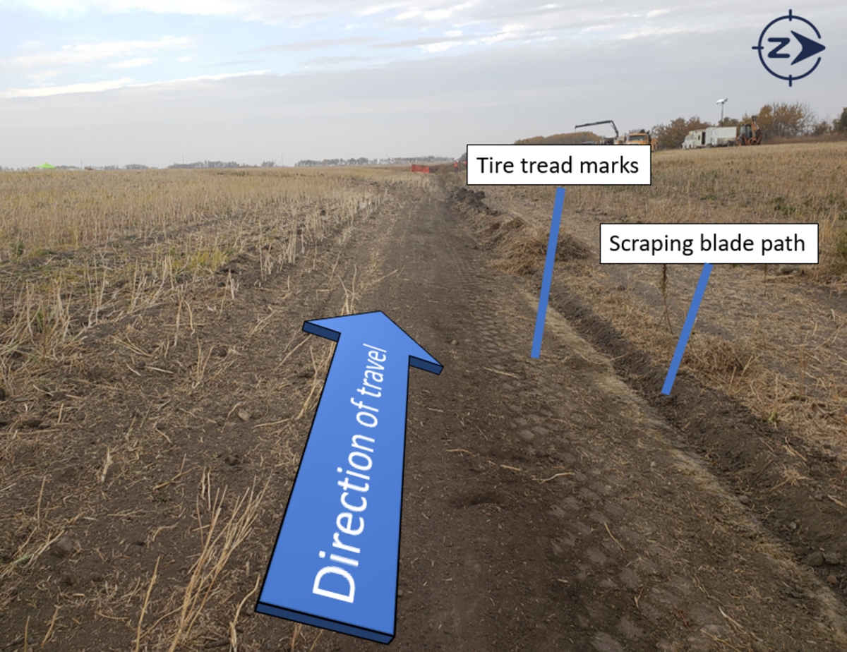 Tire tread marks and disturbed soil indicating the path of the tractor and ground-scraping blade (Source: TSB)