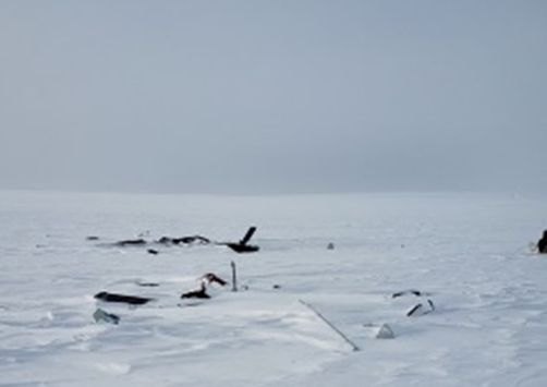 26 avril 2021: Le relief sans traits caractéristiques et uniformément couvert de neige sous un ciel couvert, sur le lieu d’un accident au Nunavut (A21C0038)