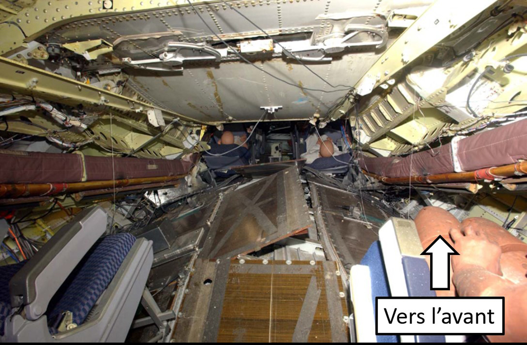 Photo de l’espace habitable (permettant la survie) réduit dans la partie centrale de la cabine par suite de l’affaissement de la voilure et de l’intrusion de la structure du train d’atterrissage principal au cours de l’essai de chute en 2006 (Source : Federal Aviation Administration des États-Unis, avec annotations du BST)