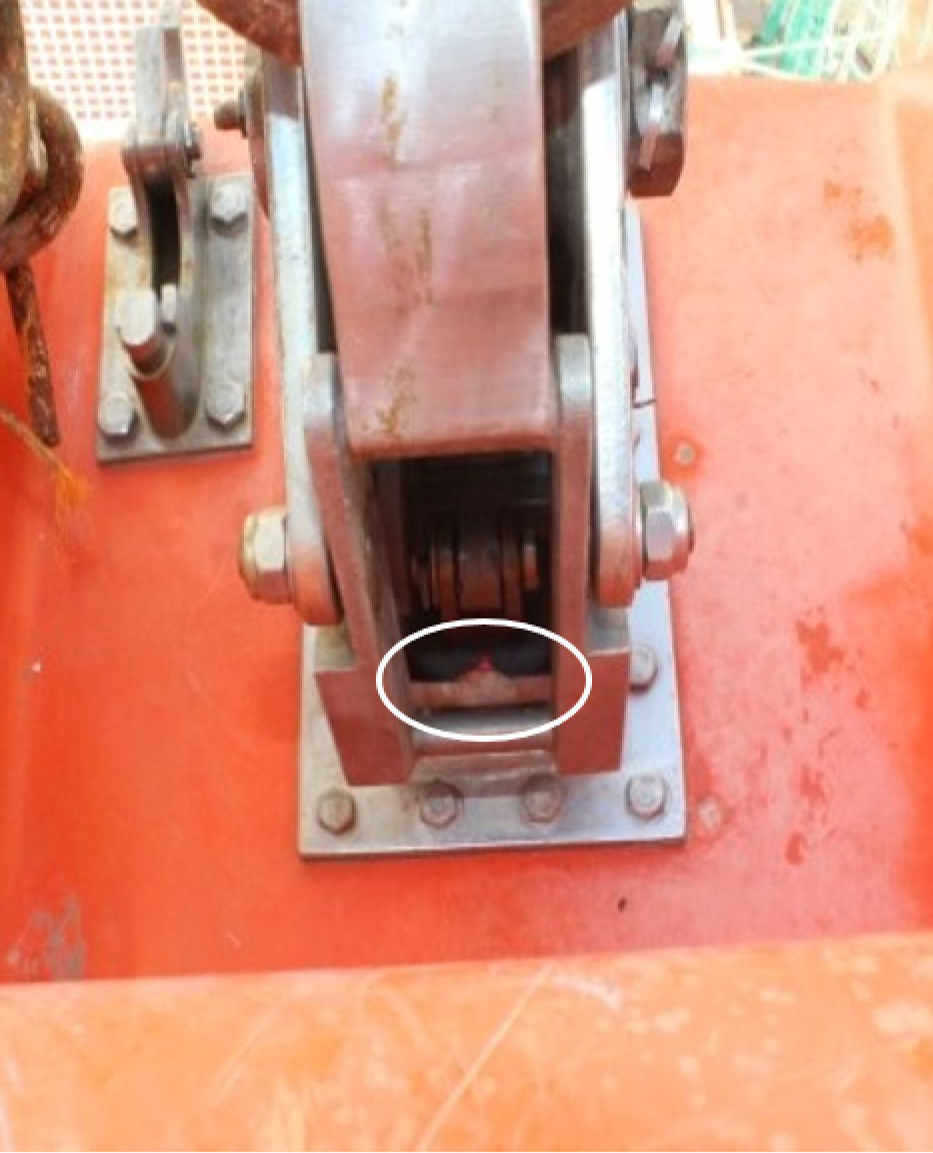 Croc de dégagement avant de l’embarcation de sauvetage en position fermée, avec indicateurs de position de verrouillage du mécanisme de largage sous tension/hors tension alignés (cercle blanc). La vue de l’opérateur serait obstruée par l’aménagement du pont. (Source : BST)