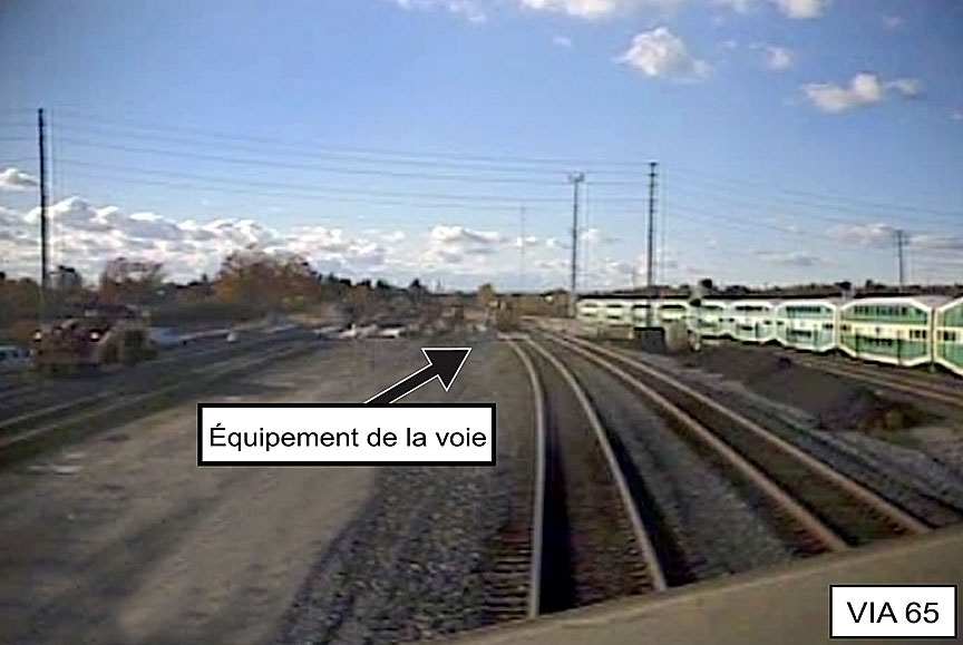 Vue à partir du train VIA 65 immobilisé à environ 500 pieds de l'équipement d'entretien se trouvant sur la même voie que le train 